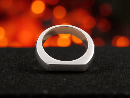 Titanium D-shape ring with brushed matte finish on black textured surface