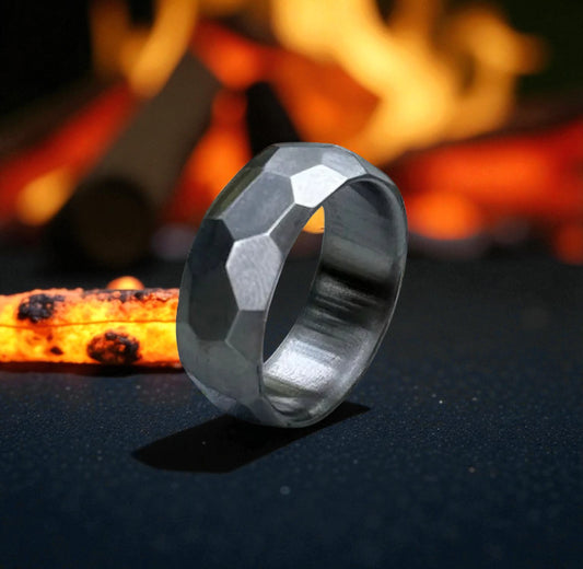 A ring illuminated against a black background, with flames flickering around it, creating a dramatic effect.