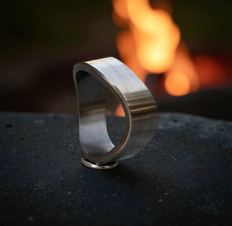 Titanium ring with brushed matte finish and curved design on dark stone surface