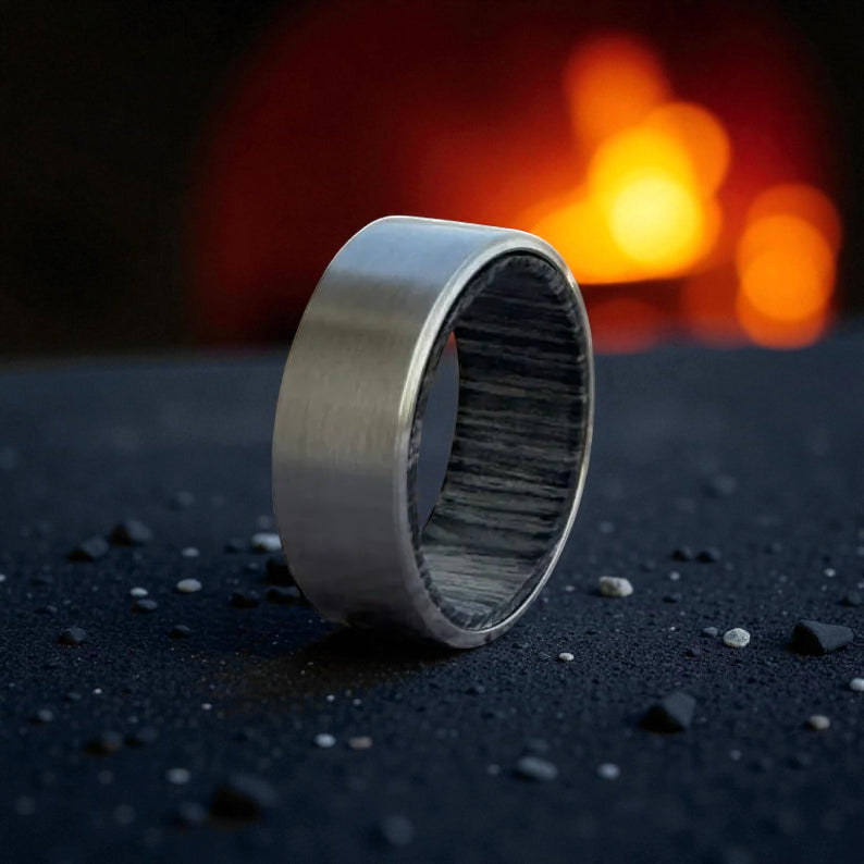 Close-up of titanium flat ring showcasing brushed texture and grey wooden inner lining