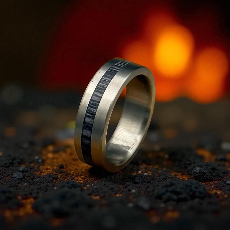 Close-up of titanium and whiskey barrel wood ring showing detailed grey inlay and soft brushed texture
