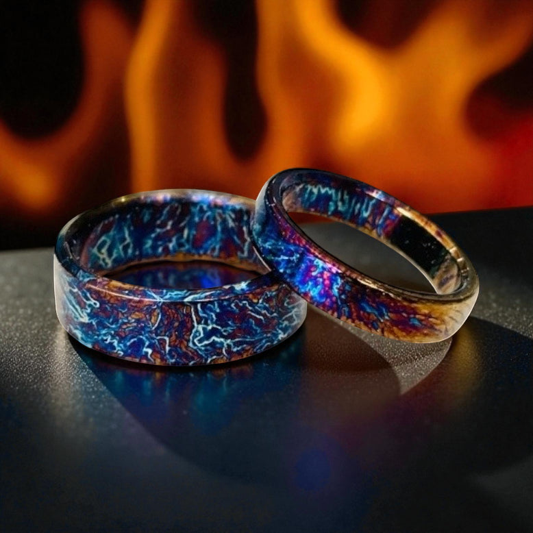 Pair of titanium rings with blue and bronze electric patterns
