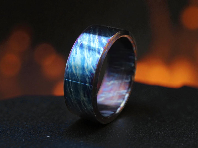 Blue lightning titanium ring on dark background with fiery glow