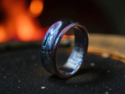 Close-up of polished titanium curved ring with electric tones and soft lighting