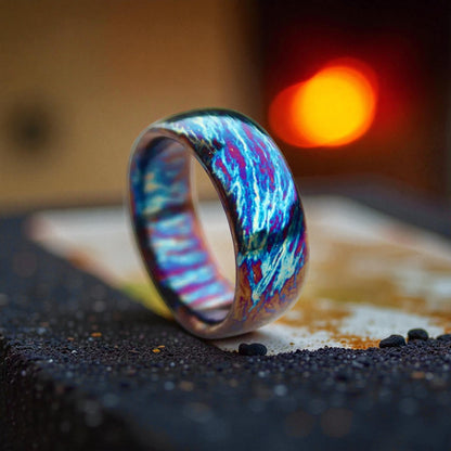 Close-up of iridescent titanium dome ring glowing with multicolor reflections