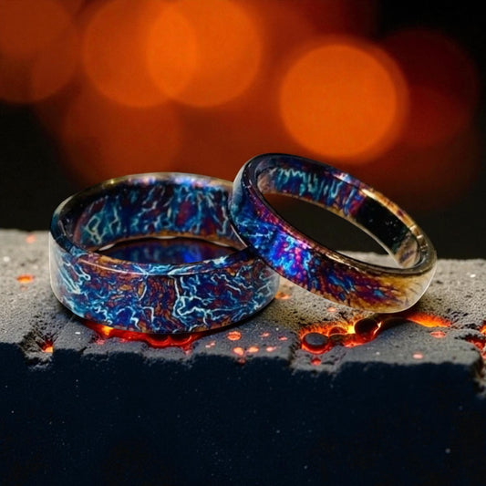 Two polished titanium rings glowing with fiery blue lightning design