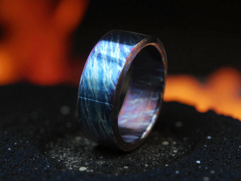 Close-up of polished titanium ring featuring vivid electric blue pattern