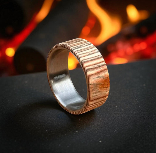 Whiskey barrel wood ring with titanium core on dark background